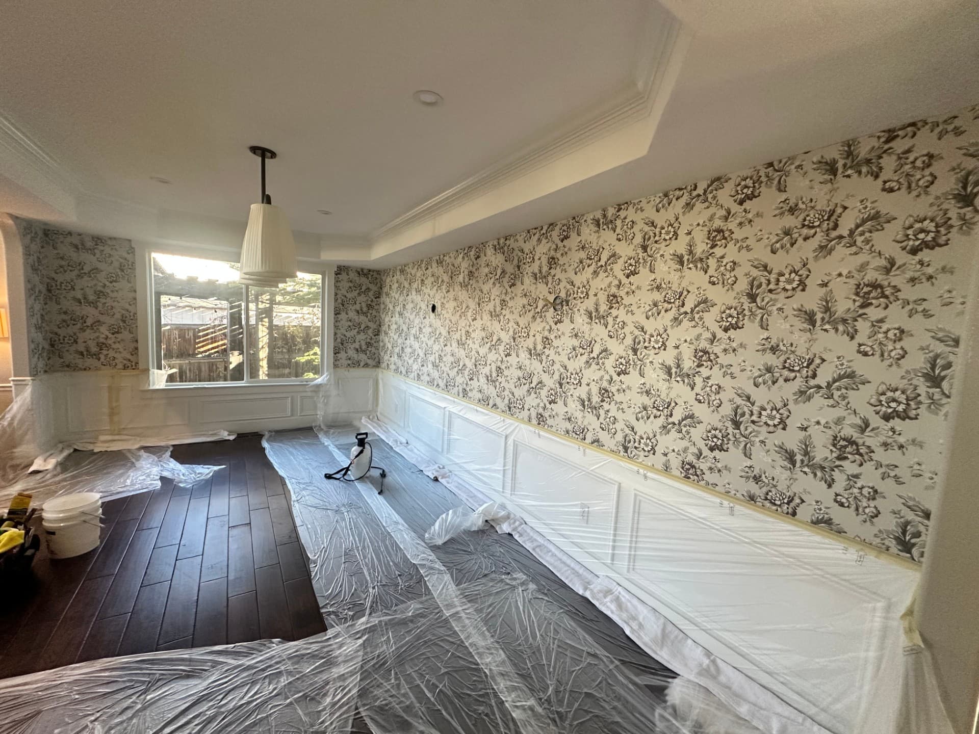 Bedroom with floral wallpaper installation in progress