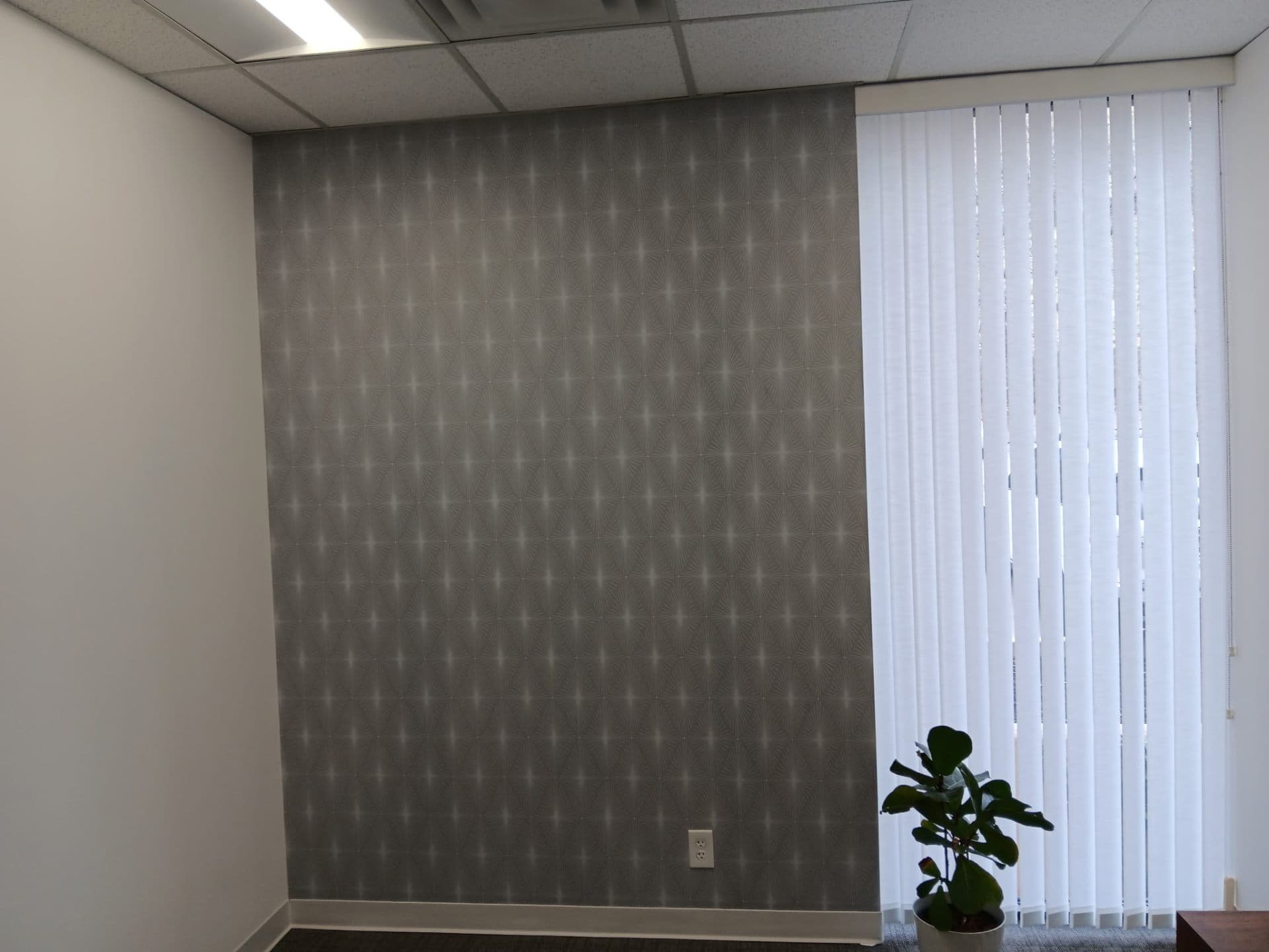 Office with dark wallpapered wall and vertical blinds