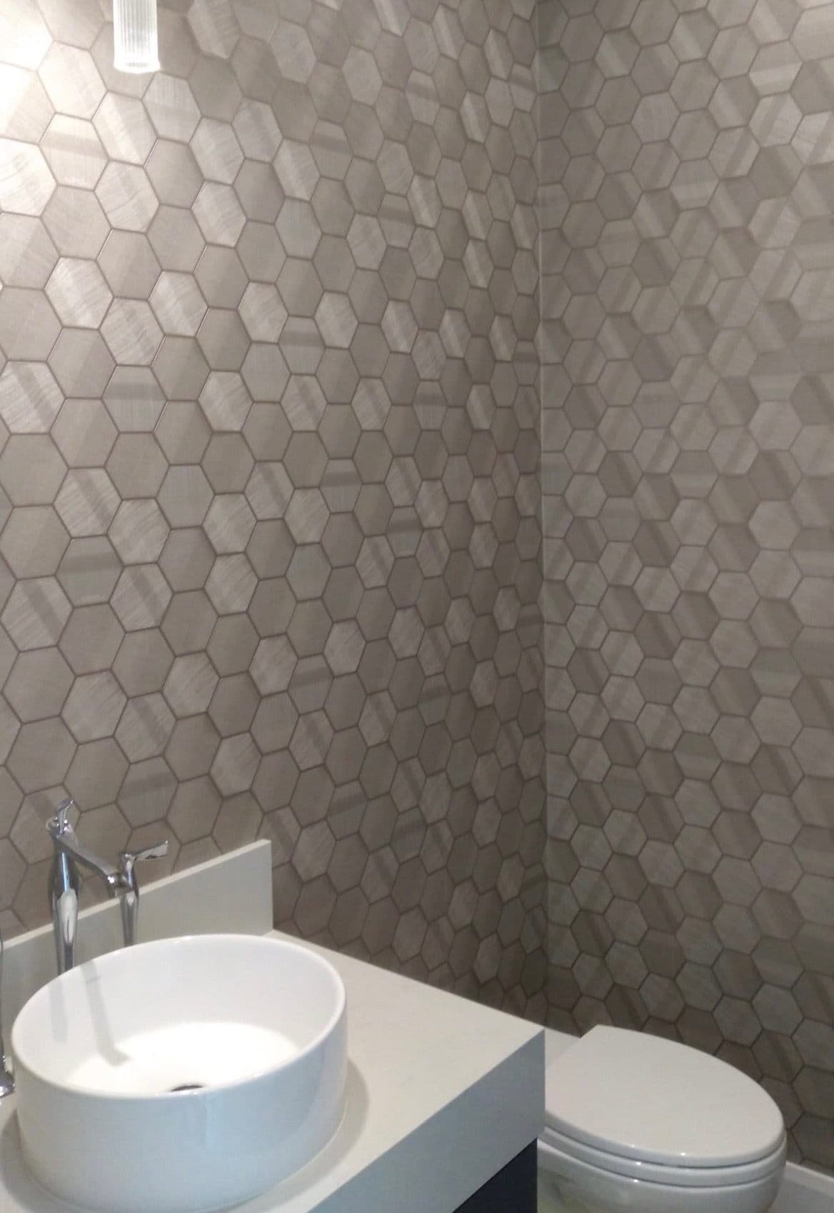 Bathroom with white hexagonal tile and accent wallpaper