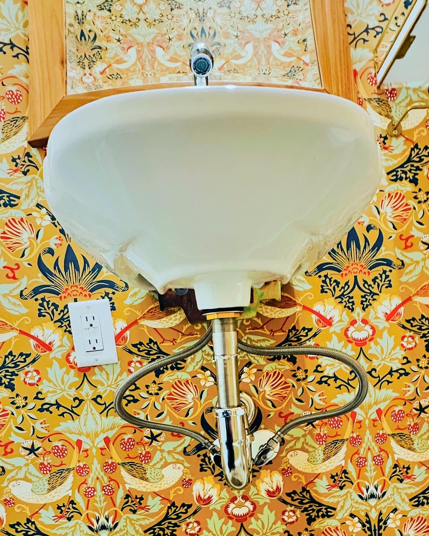 Bathroom sink with yellow and gold floral wallpaper