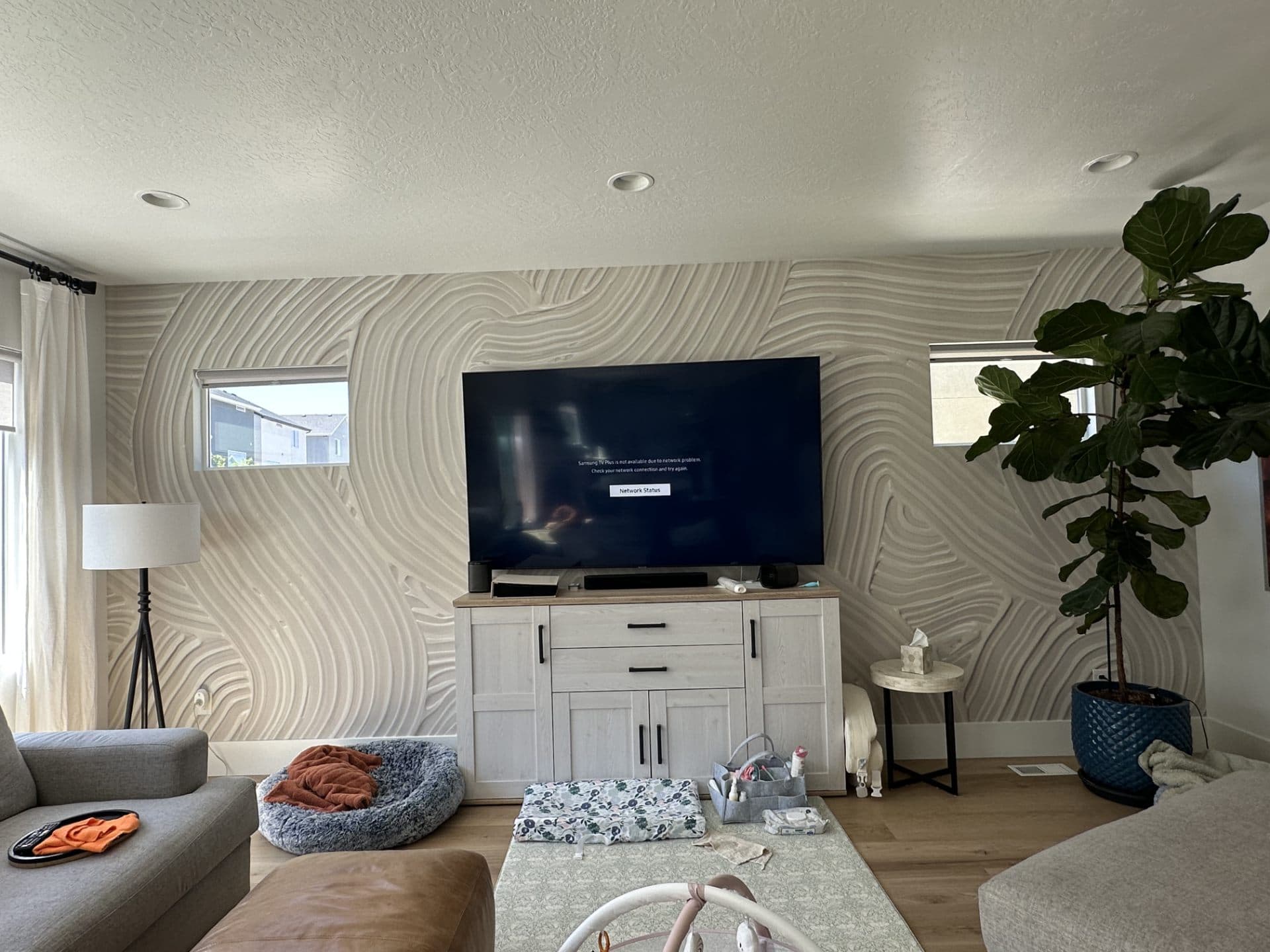 Living room with patterned accent wall behind the TV
