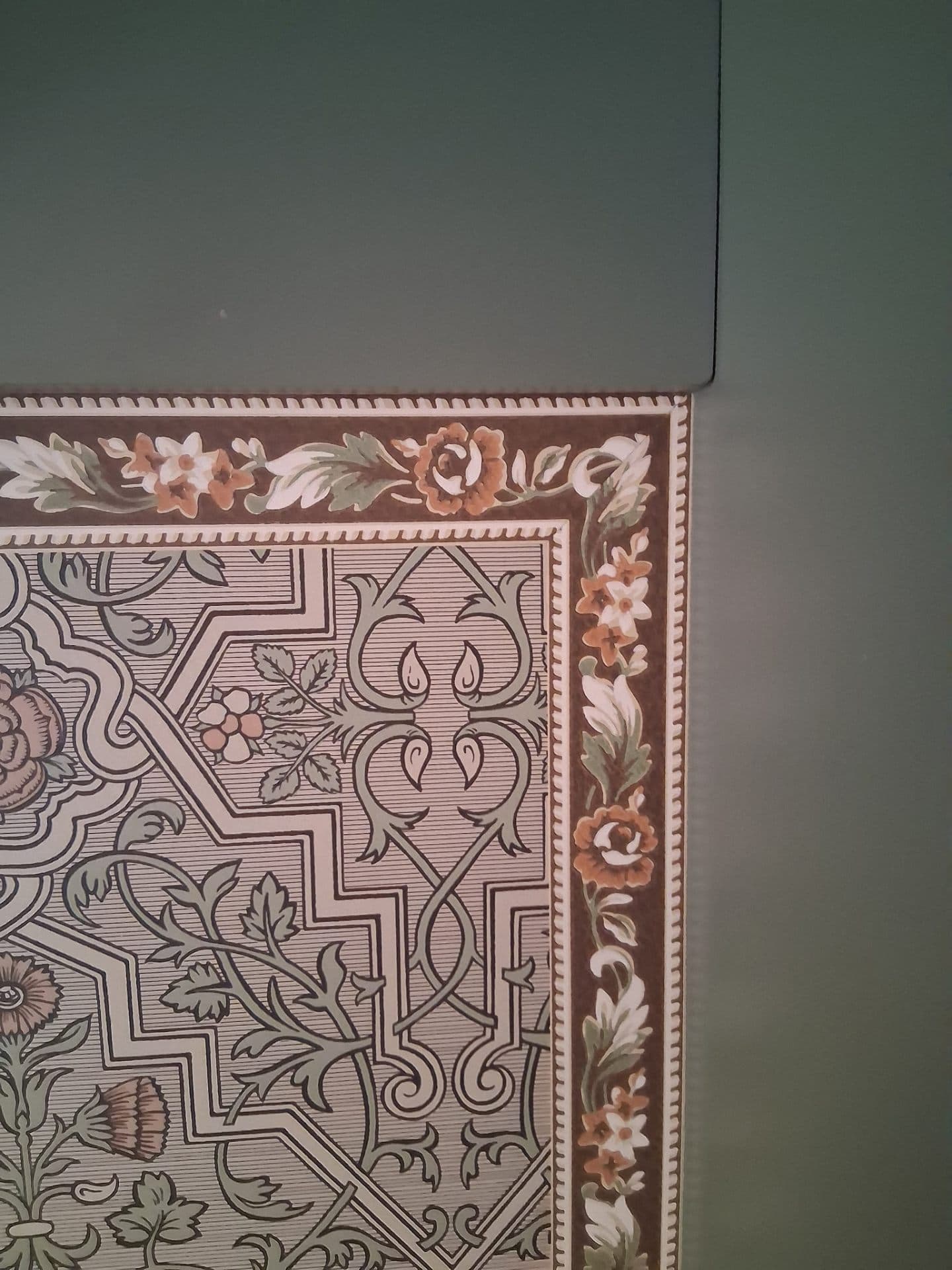 Room with ornate floral wallpaper finished with a clean border trim