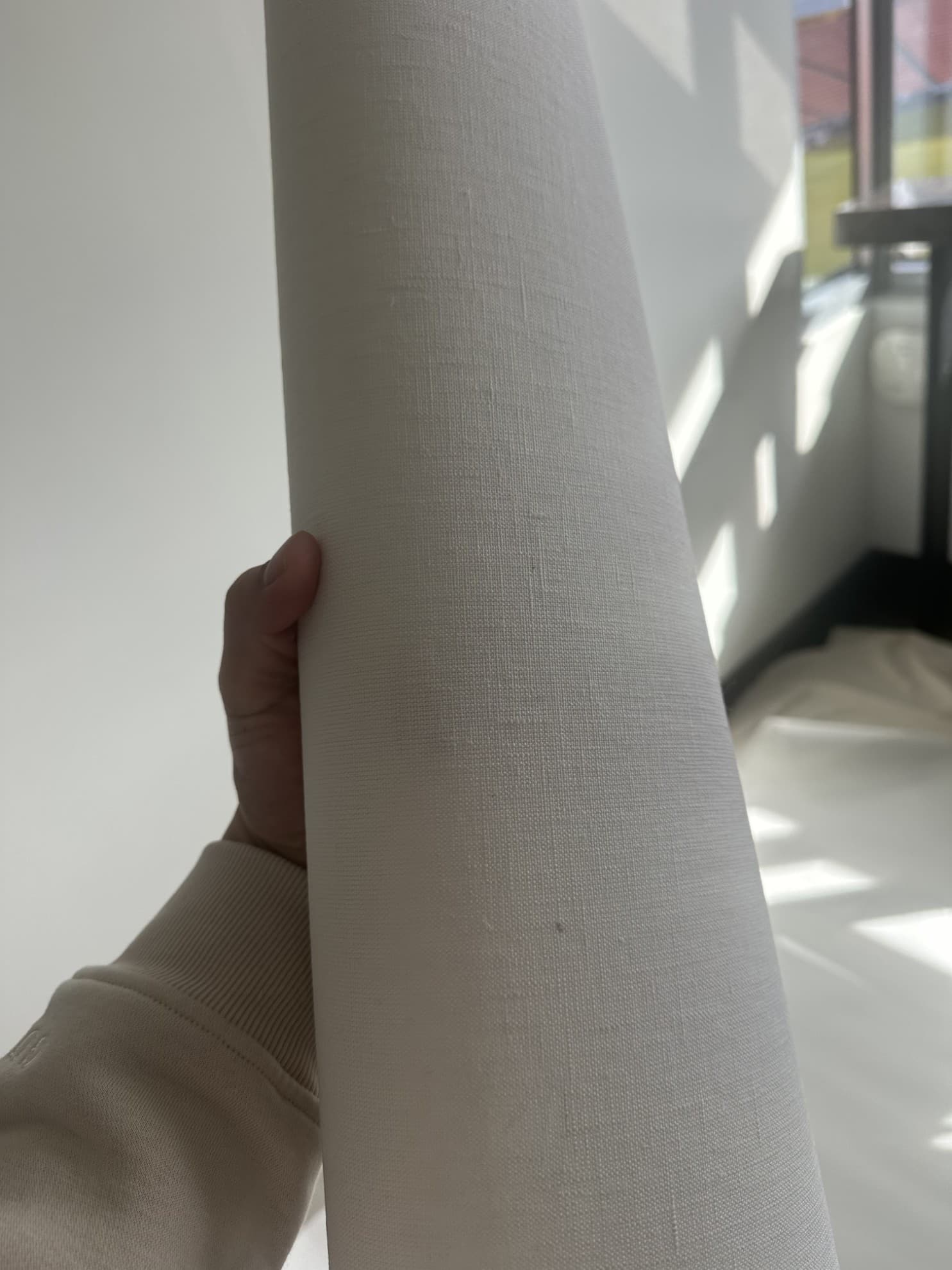 Hand resting on the finished white ribbed wallcovering inside the stadium