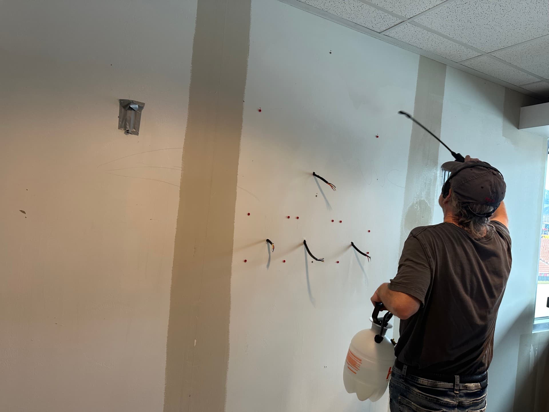 Drywall compound being sprayed on walls during commercial prep