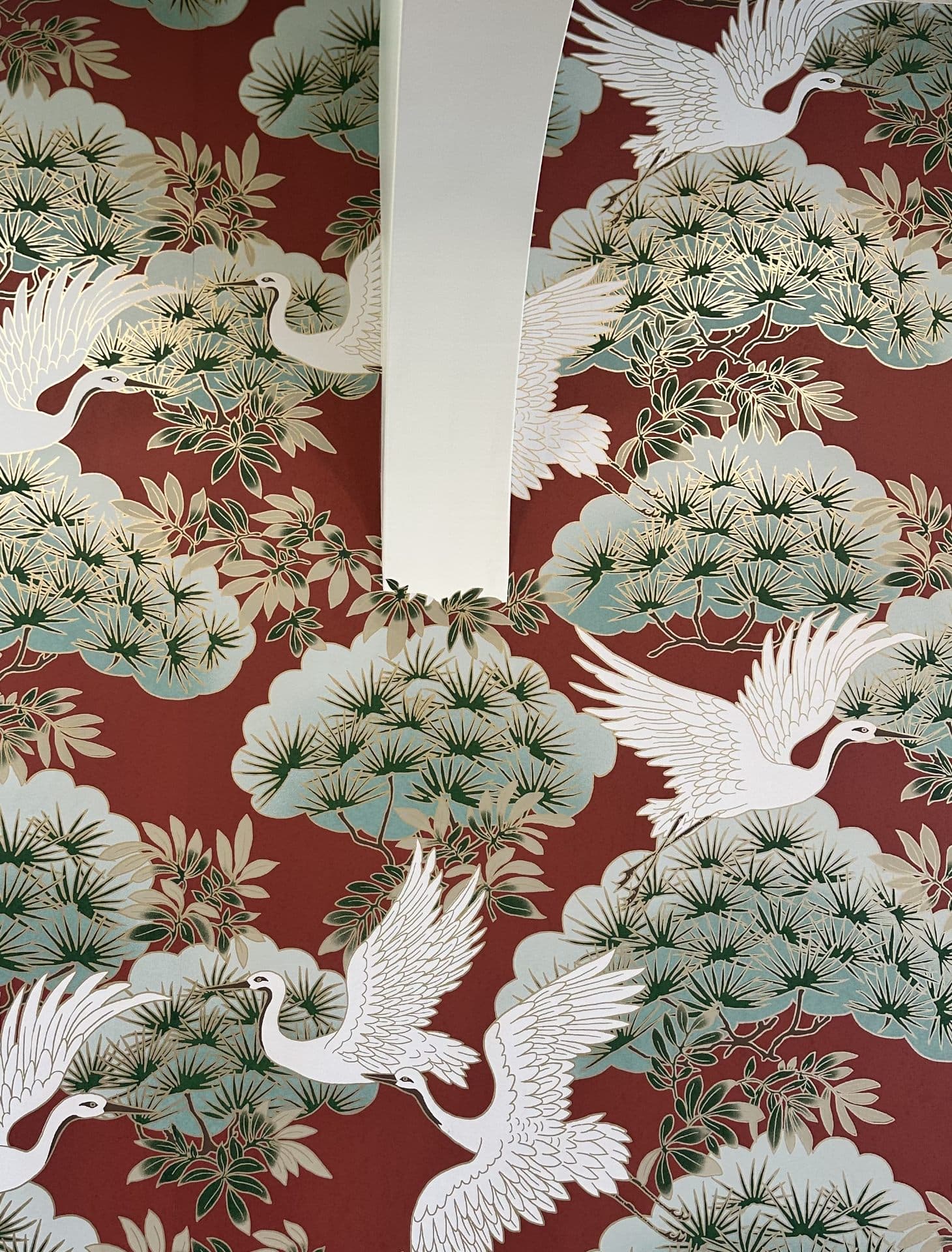 Dining room with burgundy botanical mural featuring cranes and pine branches