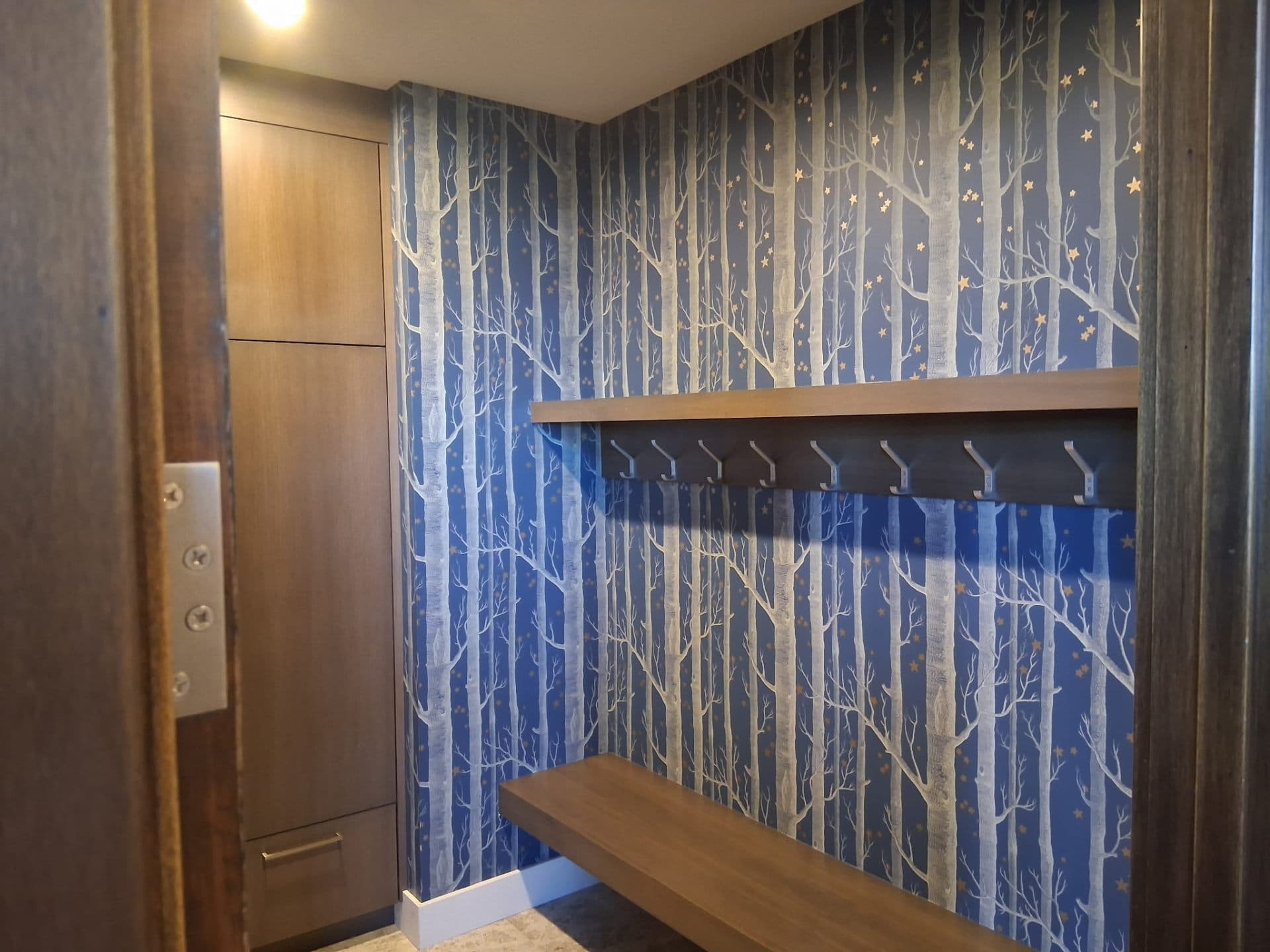 Entryway with blue forest scene wallpaper