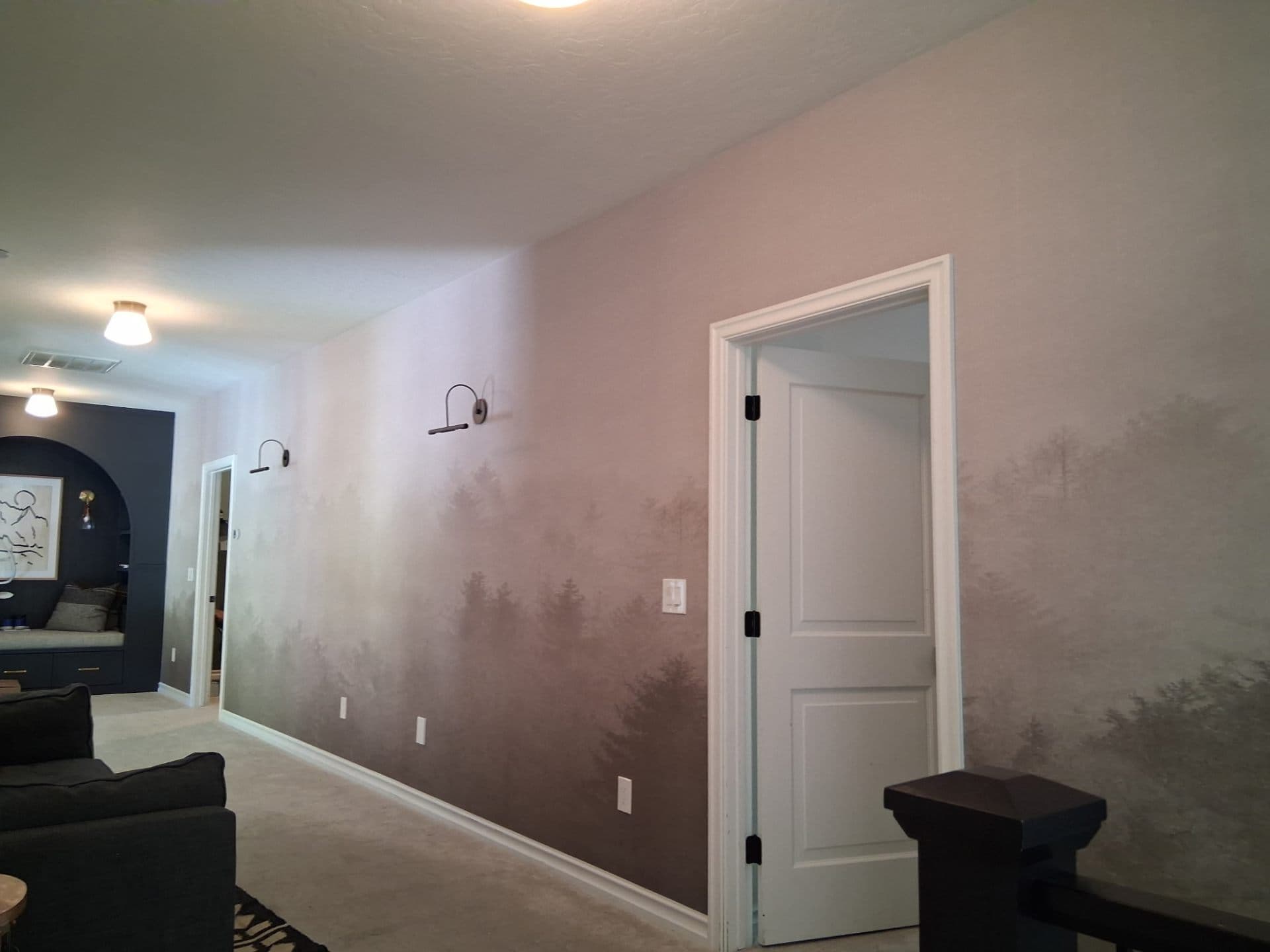 Hallway with forest mural meeting pink walls