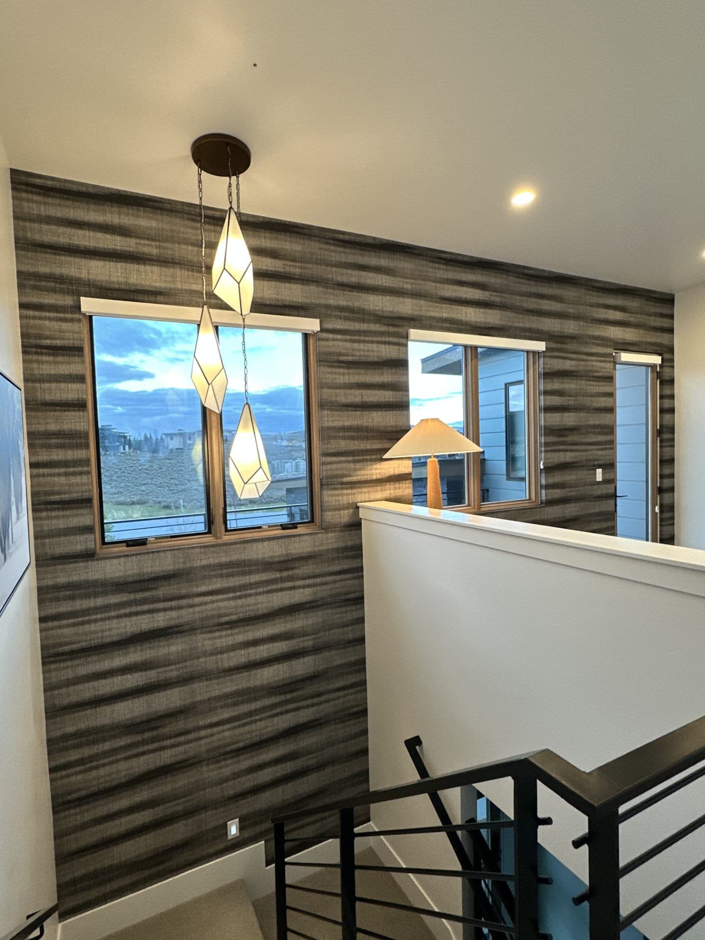 Modern staircase with mountain view through the window and wallpapered wall